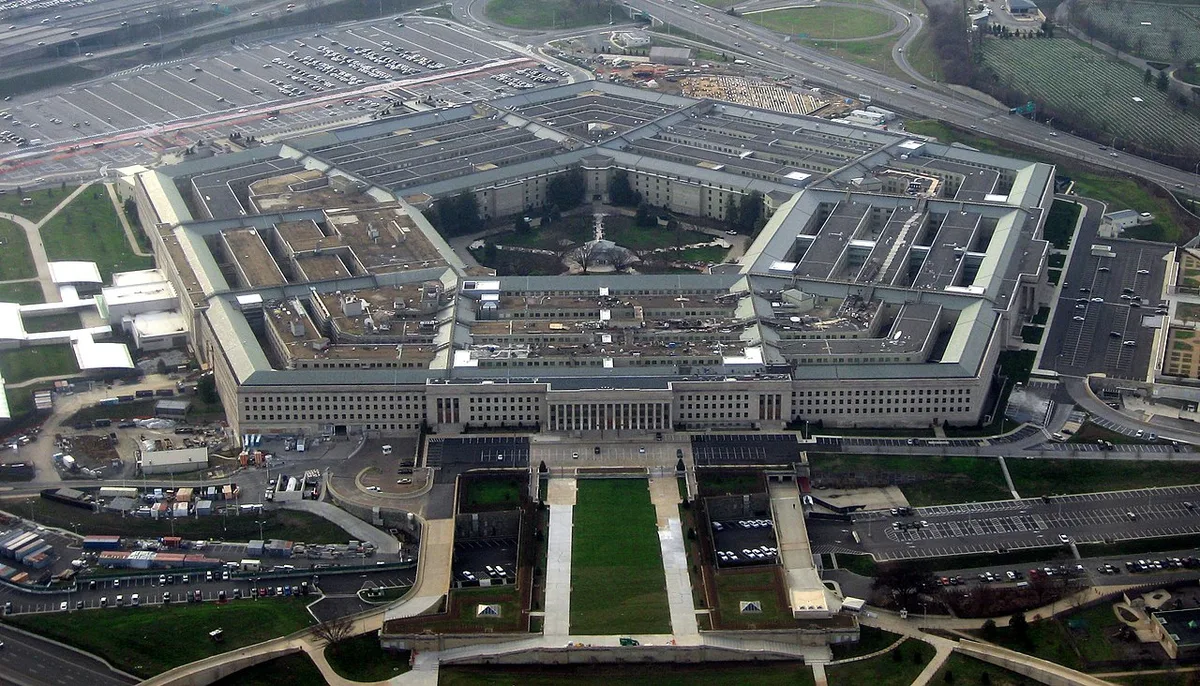 Aerial photograph of the five-sided Pentagon building surrounded by parking lots and highways.
