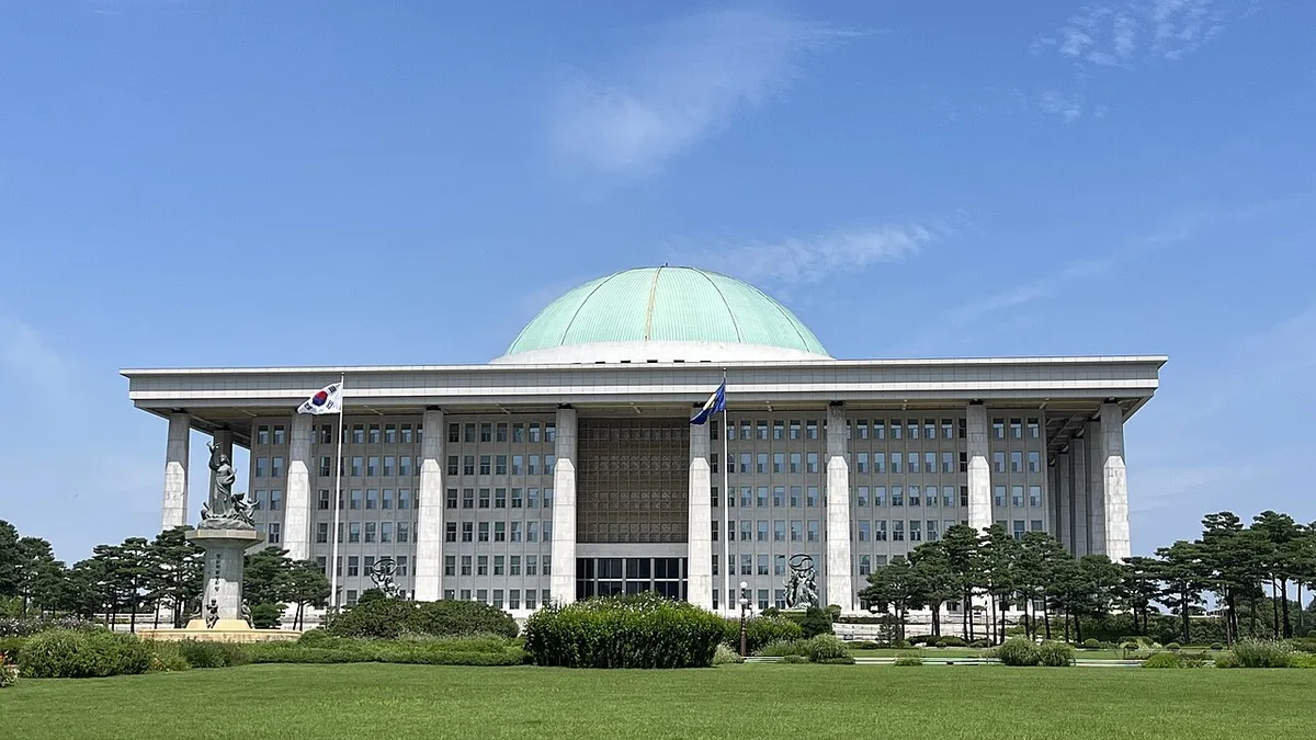 Wide exterior view of the domed South Korean National Assembly building under a clear sky.