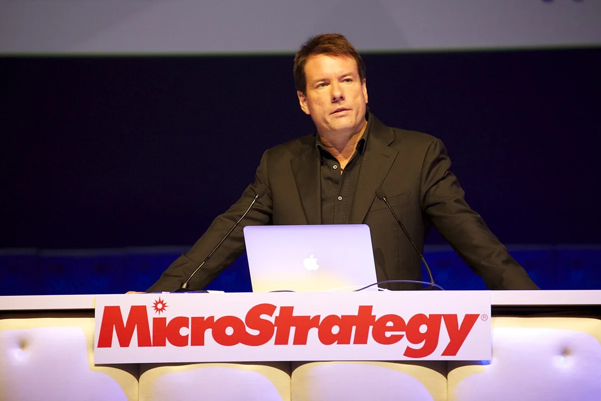 Michael Saylor speaking at a podium during a keynote presentation.